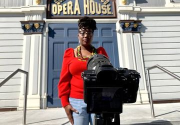 Graduate filming in front of Oakland Opera House